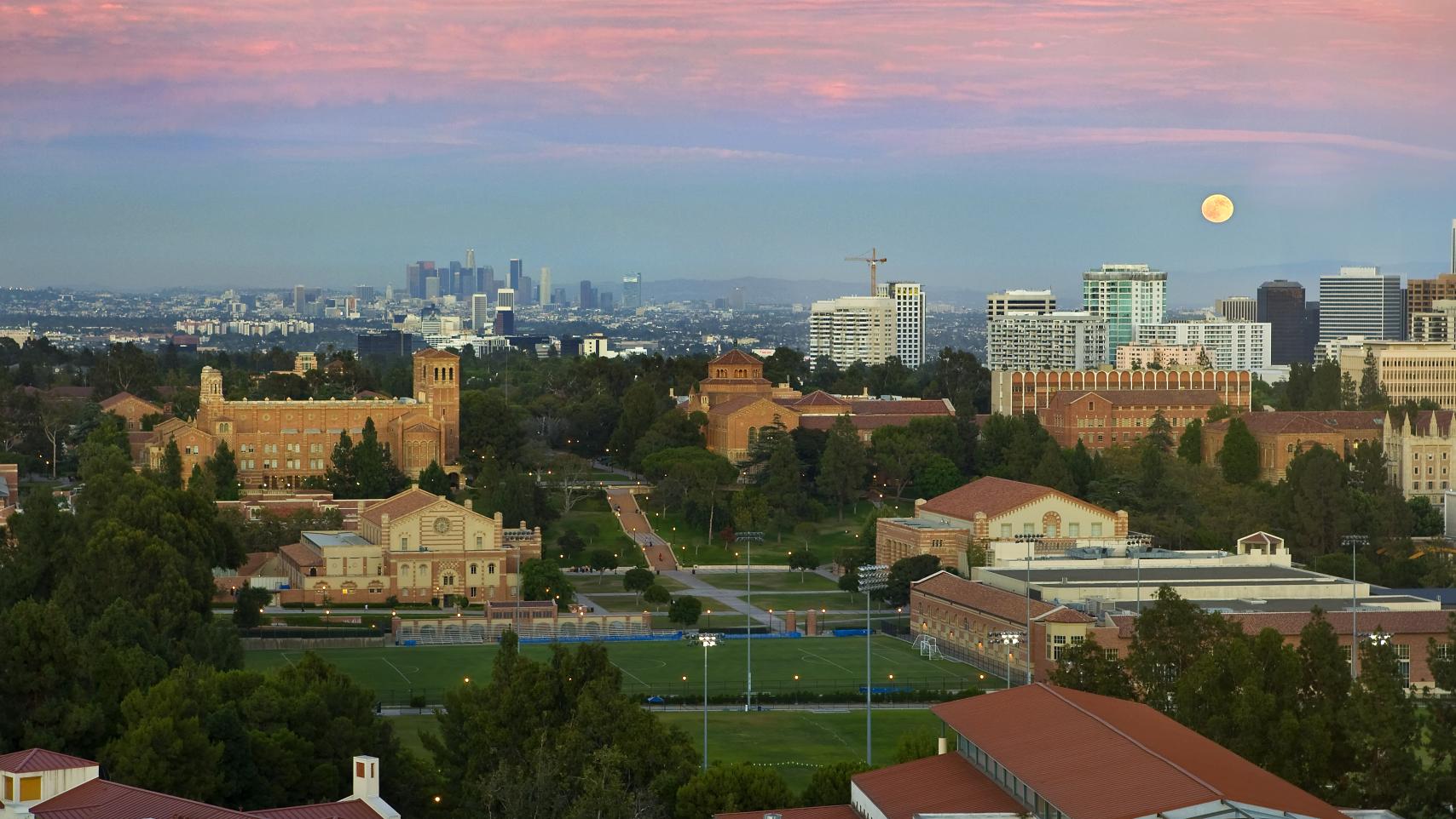 An aerial view of UCLA campus underneath a sunset and full moon.